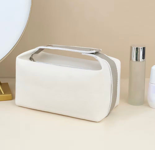 Krämvit makeup bag i canvas med öppningsbart bärhandtag och dragkedja från Natta Collection.