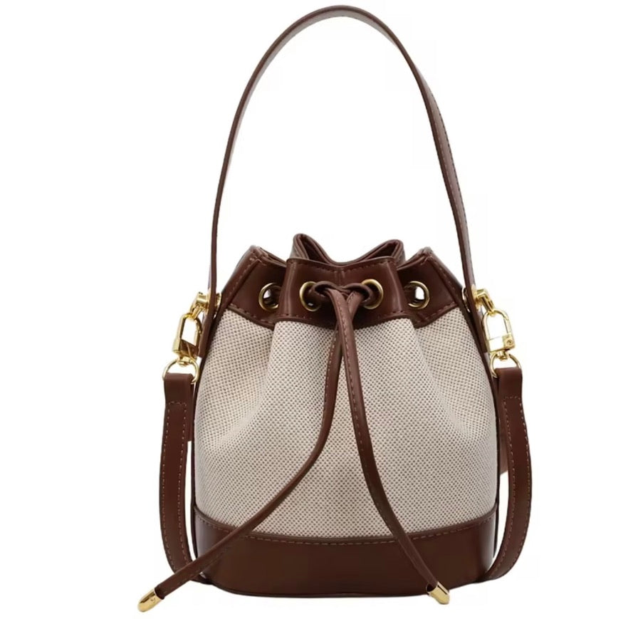 Brun och beige bucket bag med lång axelrem och dragskostängning från Natta Collection.