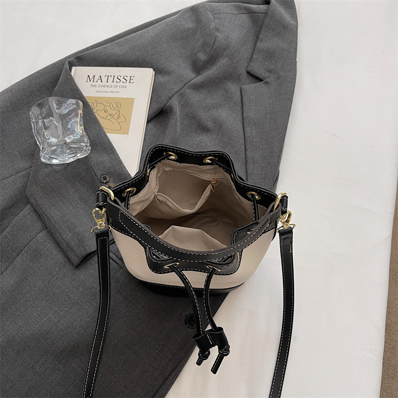 Rymlig insida med plats för mobil, plånbok och andra tillhörigheter i svart och beige bucket bag från Natta Collection.