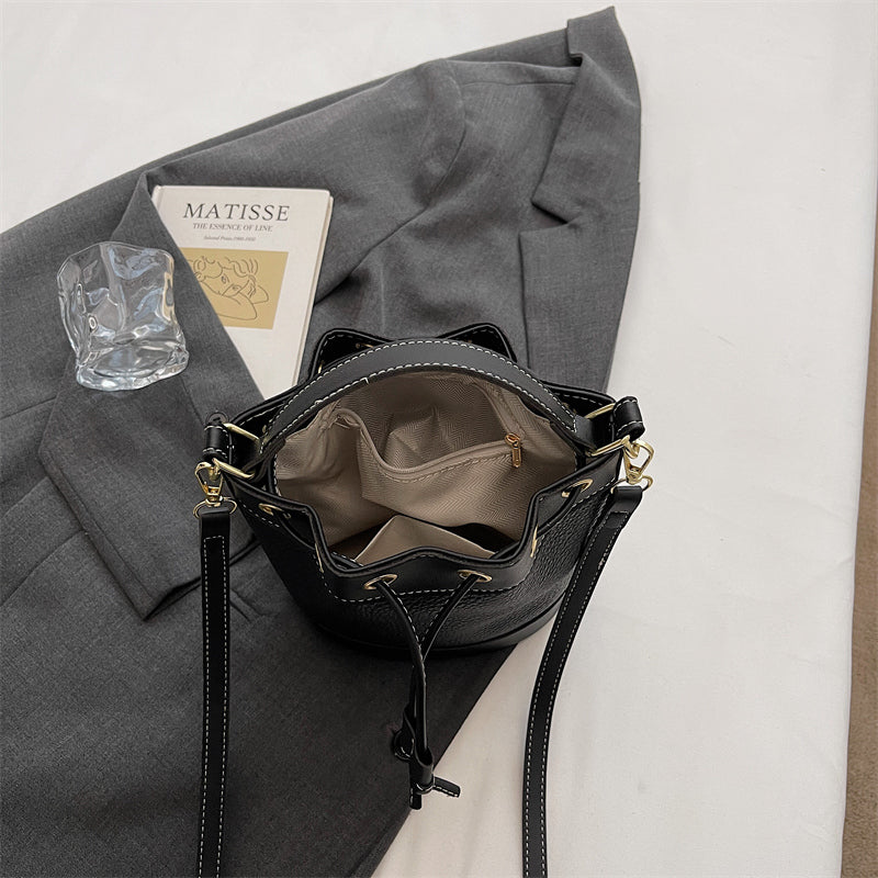 Rymlig insida med plats för mobil, plånbok och andra tillhörigheter i svart bucket bag från Natta Collection.
