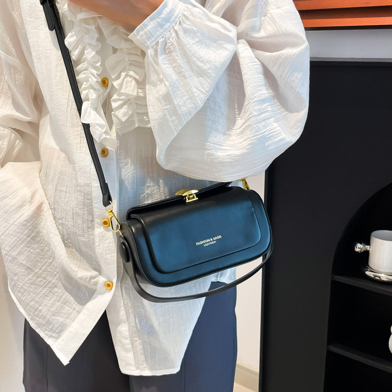 Handväska svart buren som crossbody med justerbar axelrem och kompakt modell.