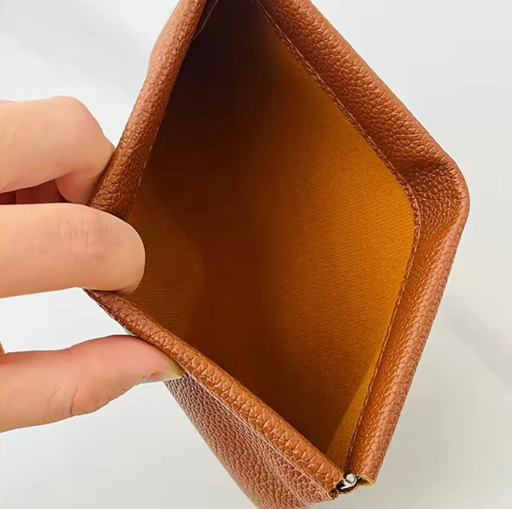 Beige förvaring i större storlek med metallspänne som öppnas med ett enkelt tryck för smycken, hörlurar, mynt och andra små tillhörigheter.