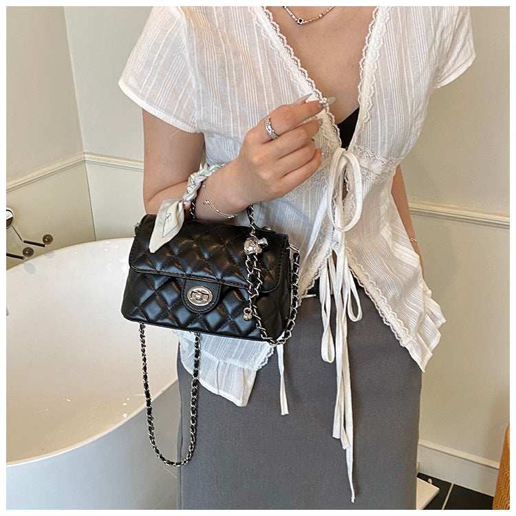 Handväska svart buren som crossbody med kedjerem och quiltad design.