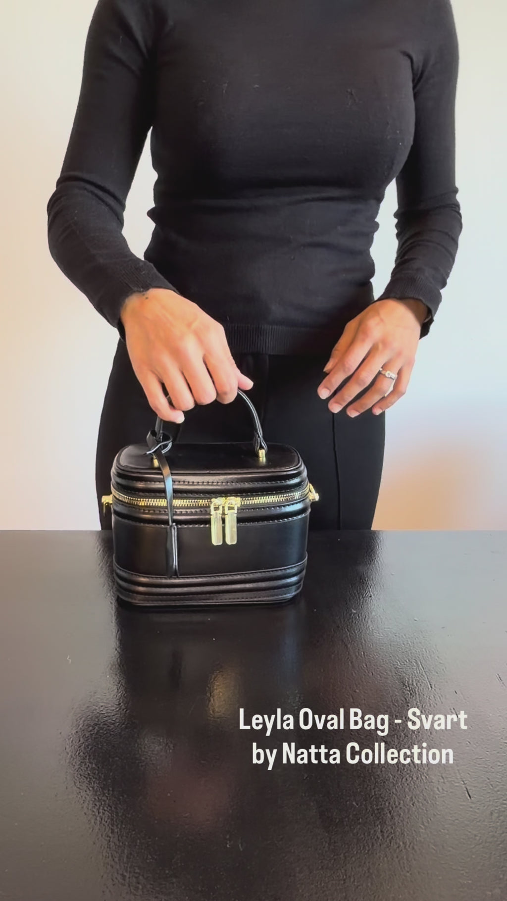 Produktvideo som visar Leyla Oval Bag i svart, en handväska med ovalformad design, handtag och guldfärgade detaljer, från olika vinklar och i närbild.