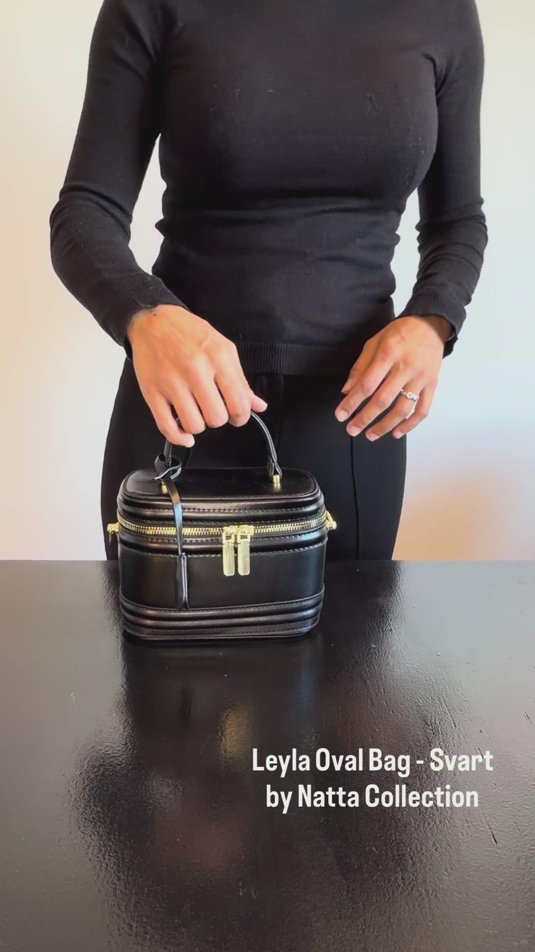 Produktvideo som visar Leyla Oval Bag i svart, en handväska med ovalformad design, handtag och guldfärgade detaljer, från olika vinklar och i närbild.