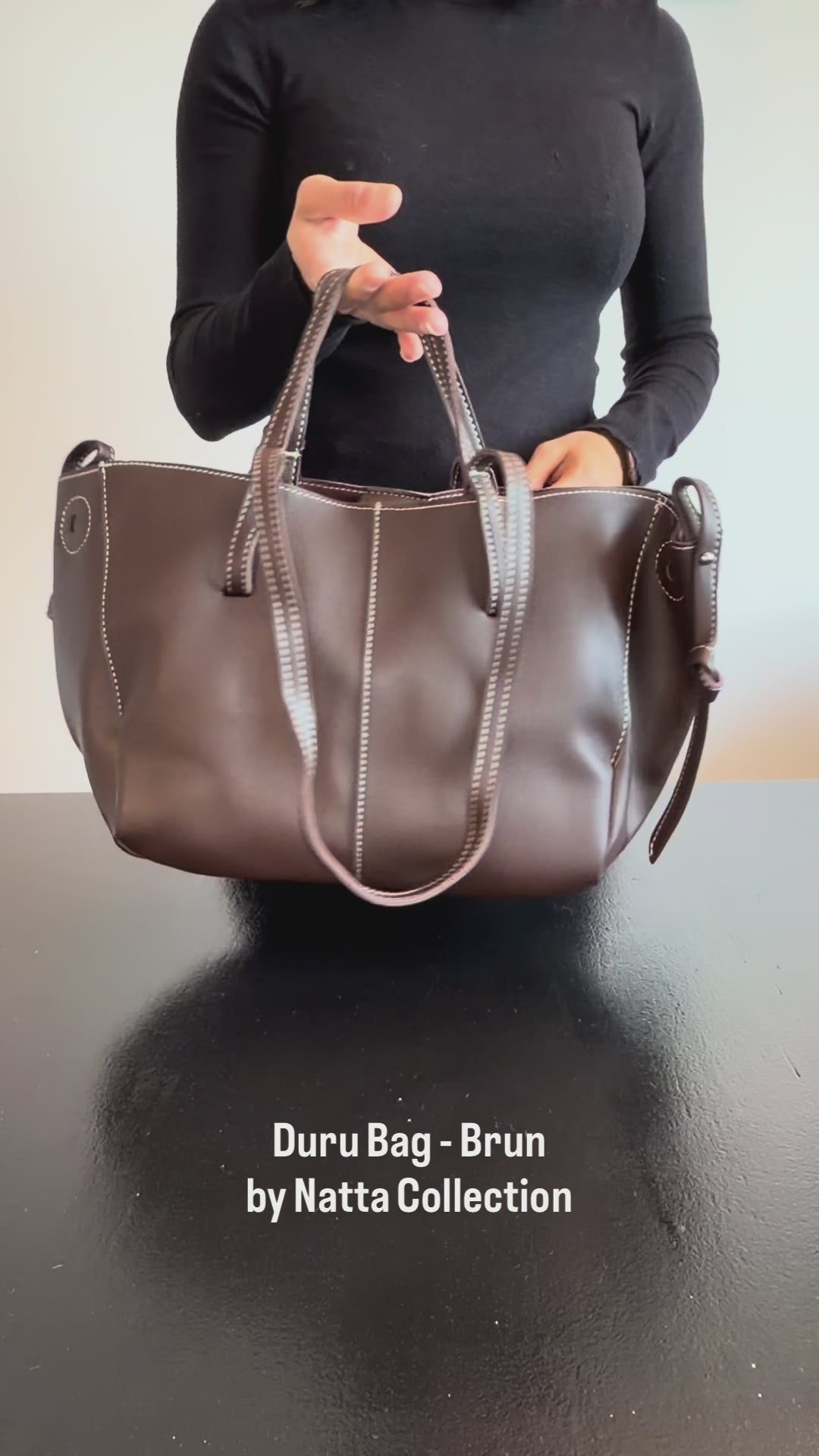 Produktvideo som visar Duru Bag, en brun tote-väska med handtag, axelrem och dekorativa sömmar, från olika vinklar och i närbild.