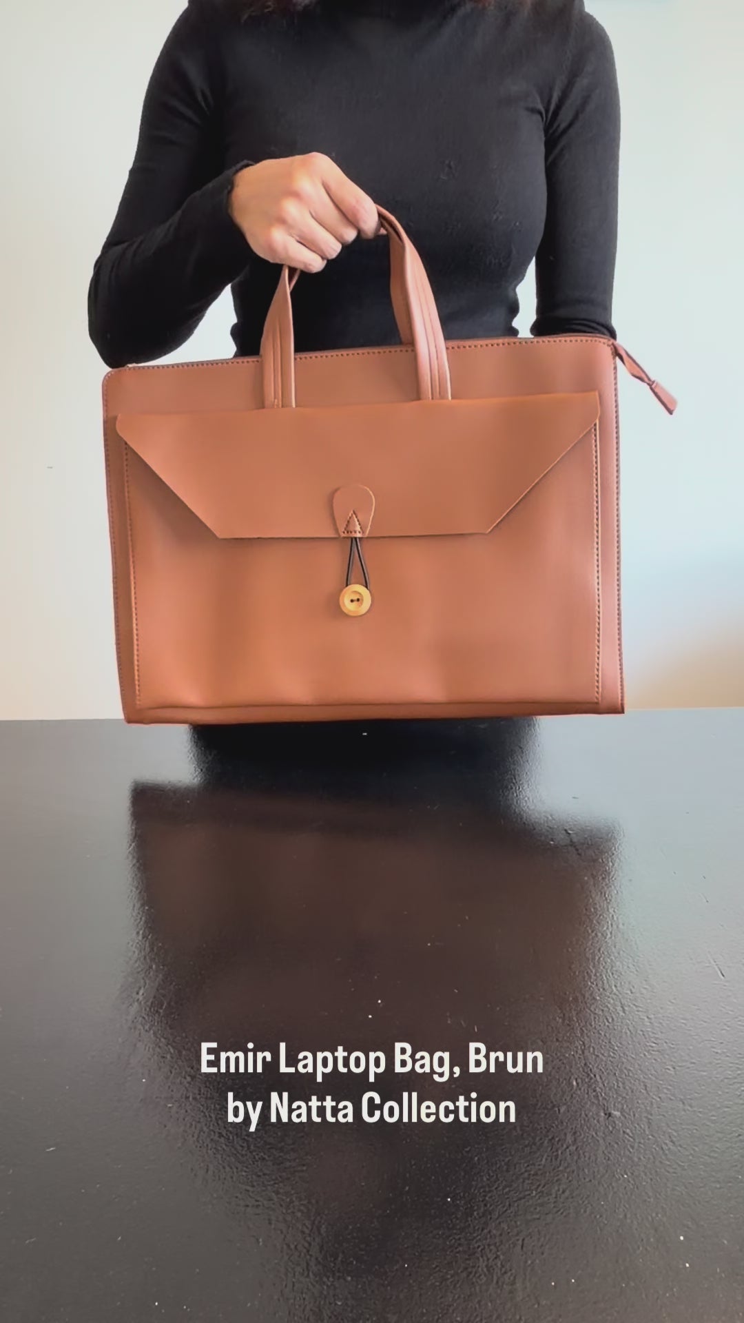 Produktvideo som visar Emir Laptop Bag, en brun datorväska med handtag, axelrem och lock med dekorativ stängning, från olika vinklar och i närbild.