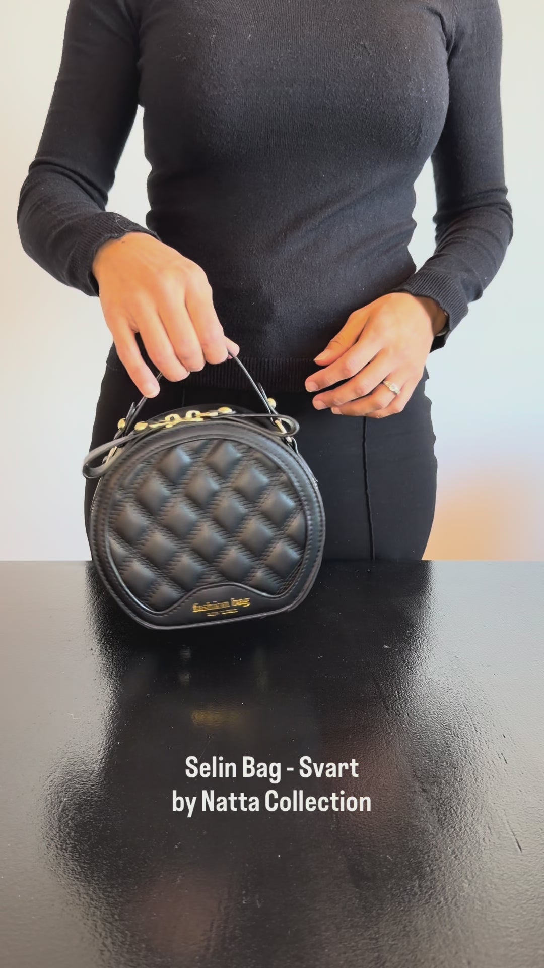 Produktvideo som visar Selin Bag i svart, en liten rund quiltad handväska med kort handtag och guldfärgade detaljer, från olika vinklar och i närbild.