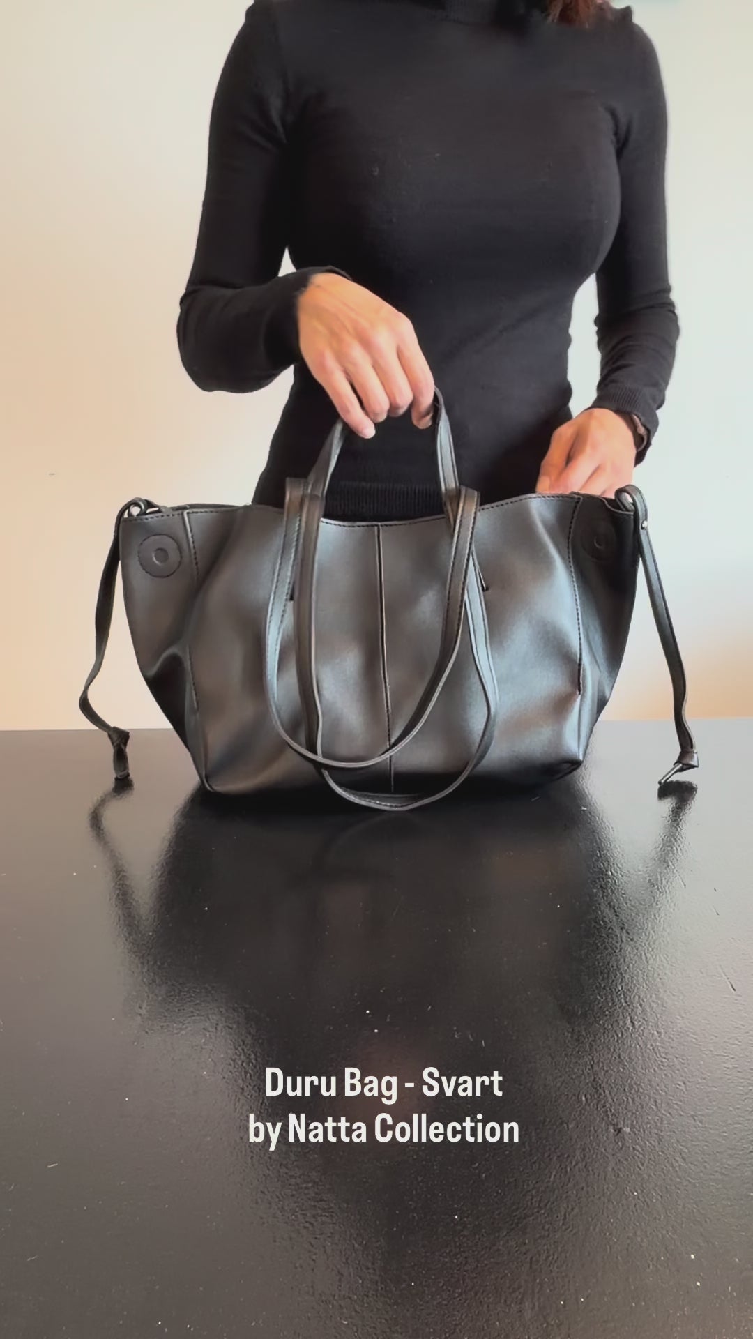 Produktvideo som visar Duru Bag, en svart tote-väska med handtag, axelrem och dekorativa sömmar, från olika vinklar och i närbild.